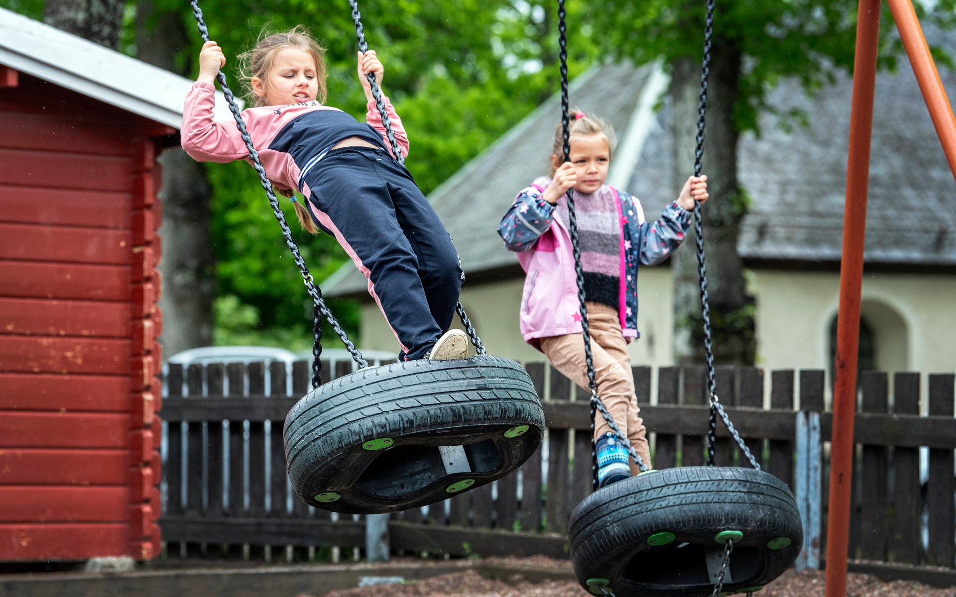 Systrarna Angelina och Evangelina Slutska, åtta respektive sex år, tar chansen att gunga under lunchrasten som de har på Källskolan i Norberg. Lektioner har de i kommunhuset ett stenkast bort.