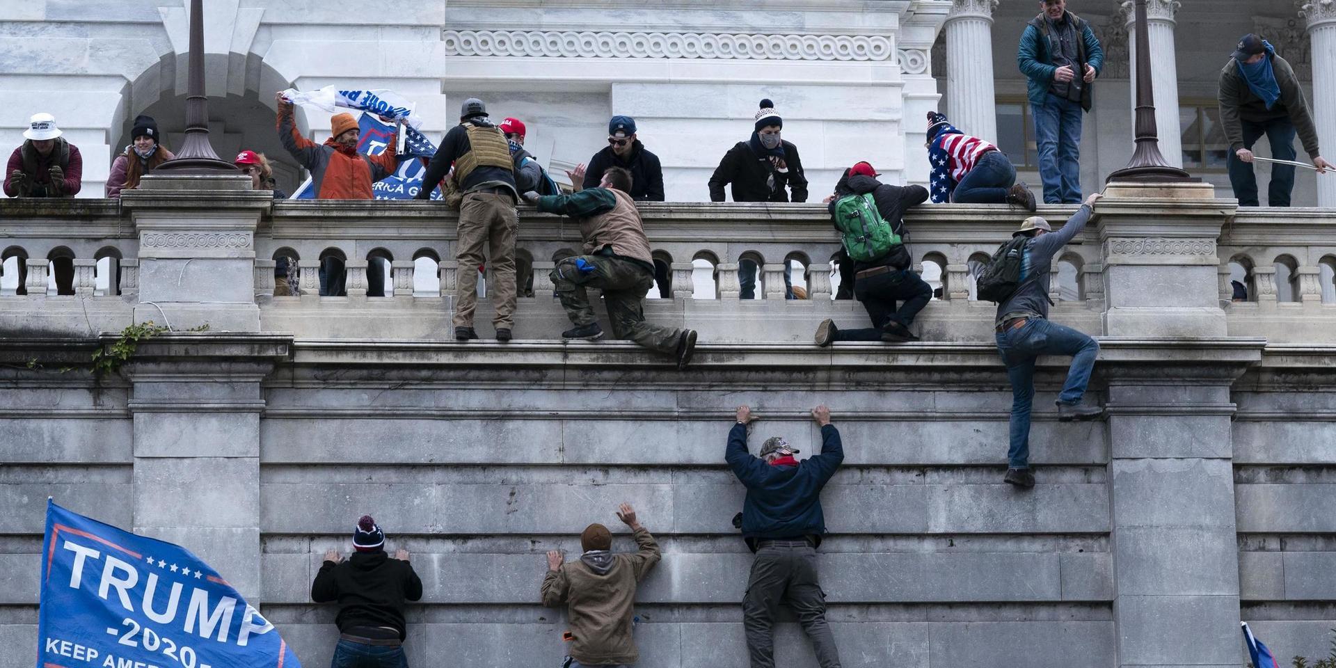 Supporters of President Donald Trump climb the West wall of the the U.S. Capitol on Wednesday, Jan. 6, 2021, in Washington. (AP Photo/Jose Luis Magana)  DCJL150