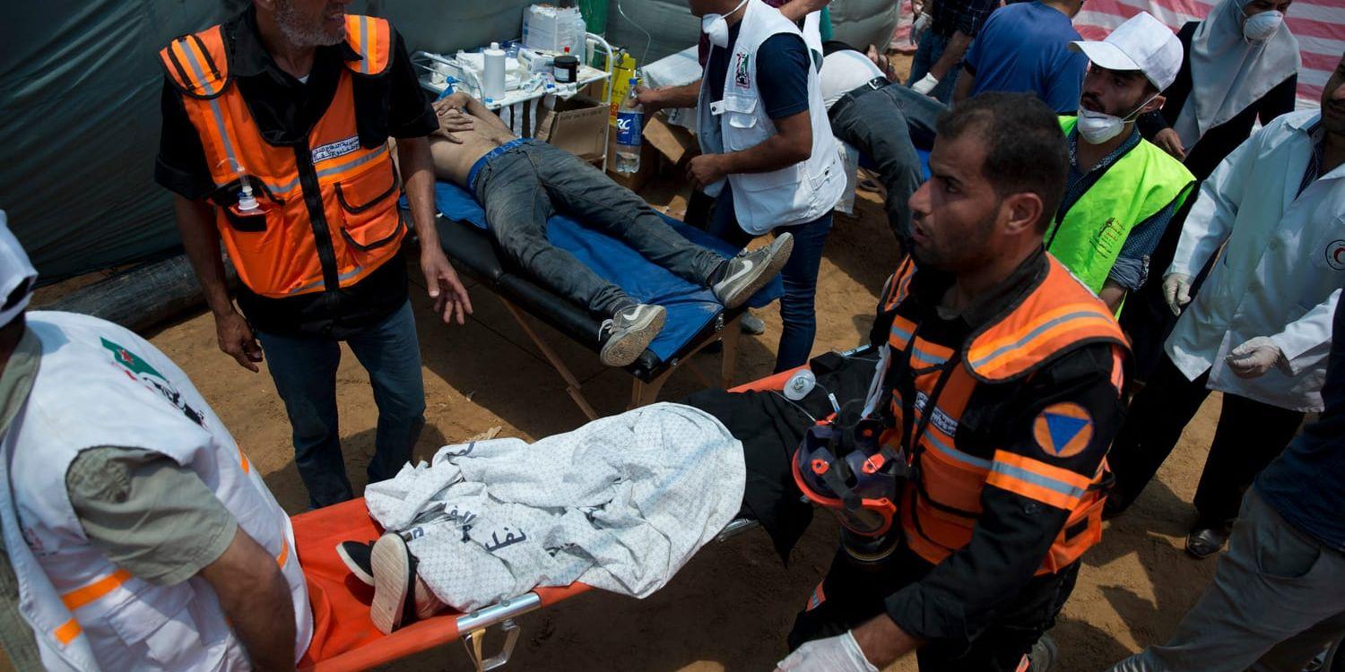 Medics treat injured Palestinians during a protest near Beit Lahiya, Gaza Strip, Monday, May 14, 2018. Israeli soldiers shot and killed dozens of Palestinians during mass protests along the Gaza border on Monday. It was the deadliest day there since a devastating 2014 cross-border war and cast a pall over Israel's festive inauguration of the new U.S. Embassy in contested Jerusalem. (AP Photo/Dusan Vranic)