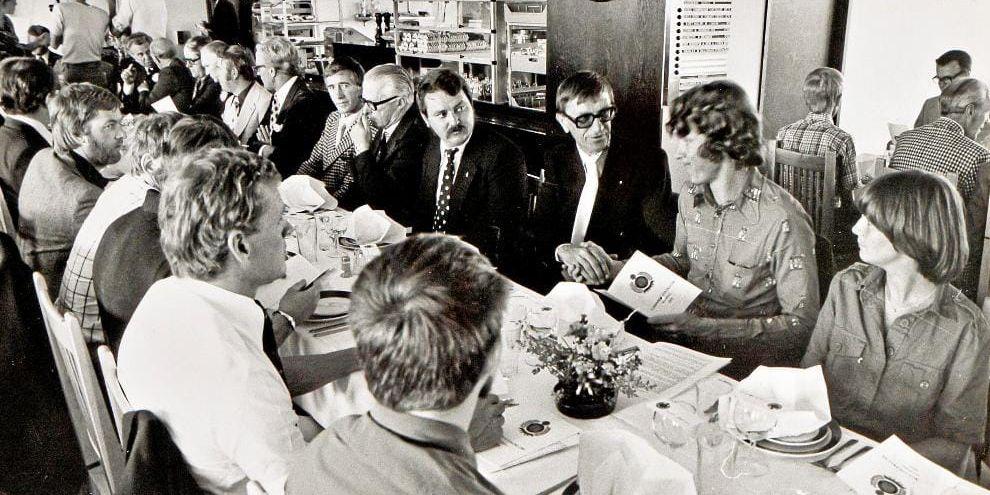 Invigningslunchen i Östra banans klubbhus den 10 juli 1976, där de inbjudna sitter bänkade. Börje Larö i mitten tar i hand och hälsar på journalisten Kenth Andreasson. Bild: Privatbild