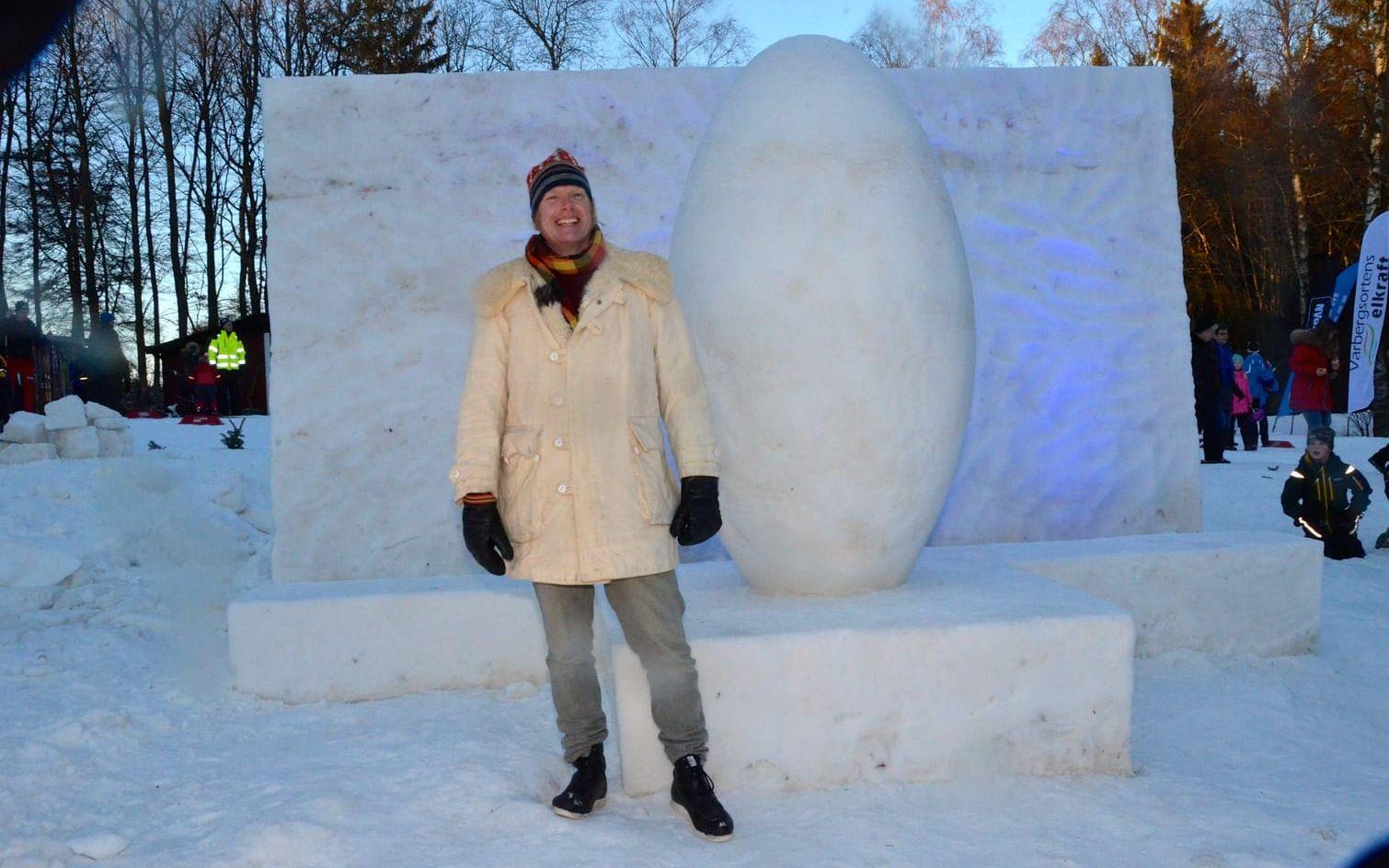 Snöskulptör. Jens Thoms Ivarsson vid sitt frö i snö. På andra sidan hade han gjort ordet åk som både får symbolisera orten och aktiviteterna där.