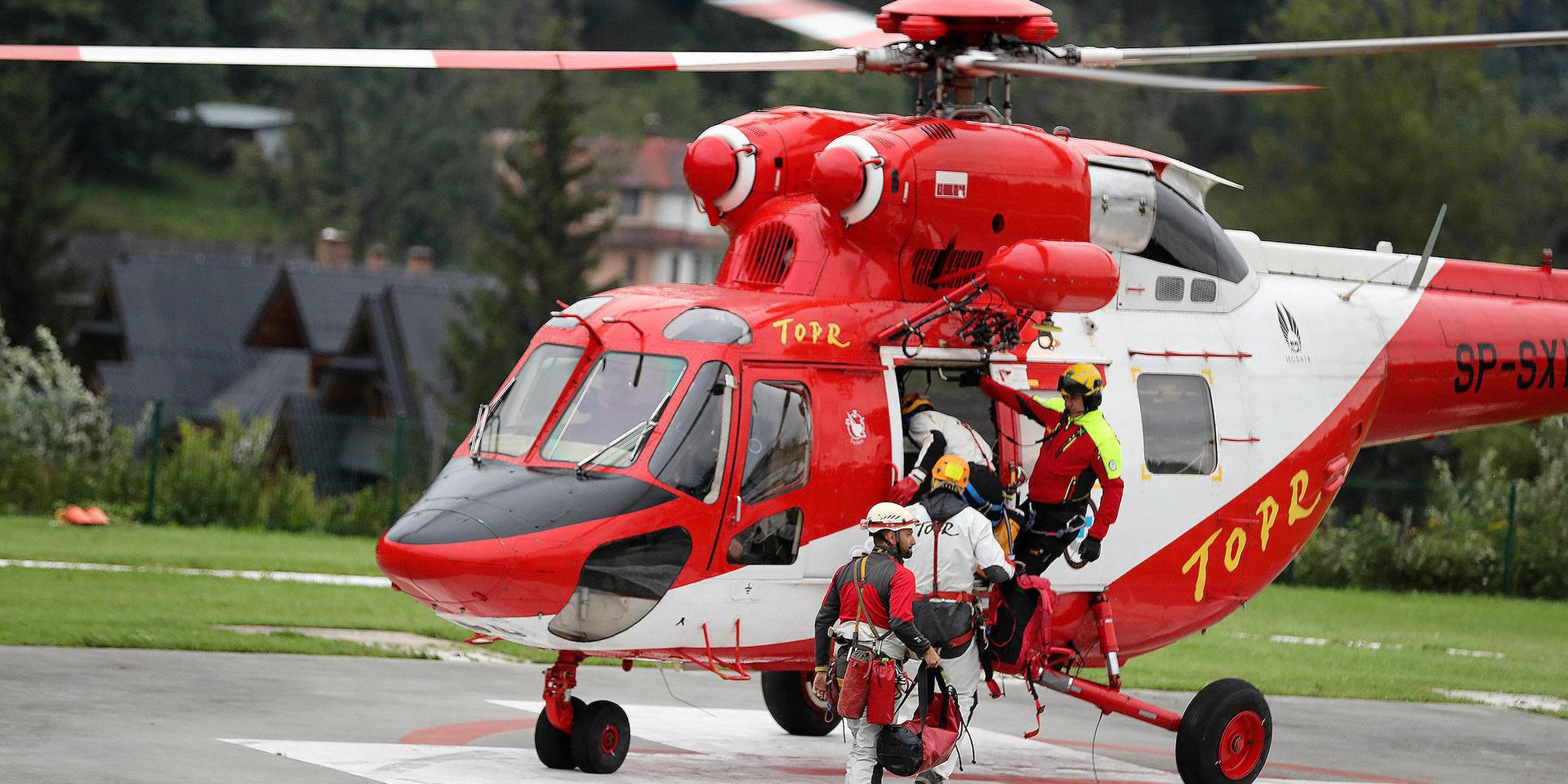 Räddningsarbetare går ombord på en helikopter för att delta i insatsen.