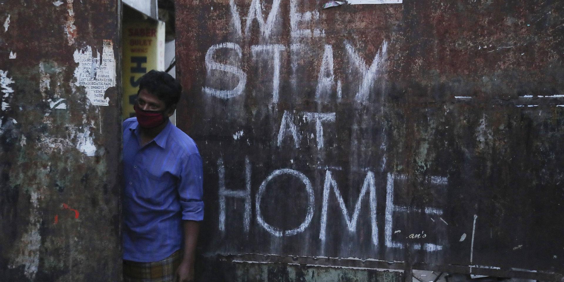 'Vi stannar hemma' har sprejats på en port i Hyderabad. Men Indien gör sig redo att slopa ännu fler virusrelaterade restriktioner. Bild från april.