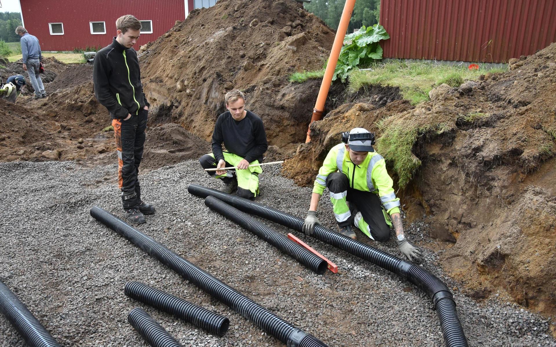 Filip Larsson, Adam Karlsson och Tim Remse mäter ut avståndet mellan avloppsrören.