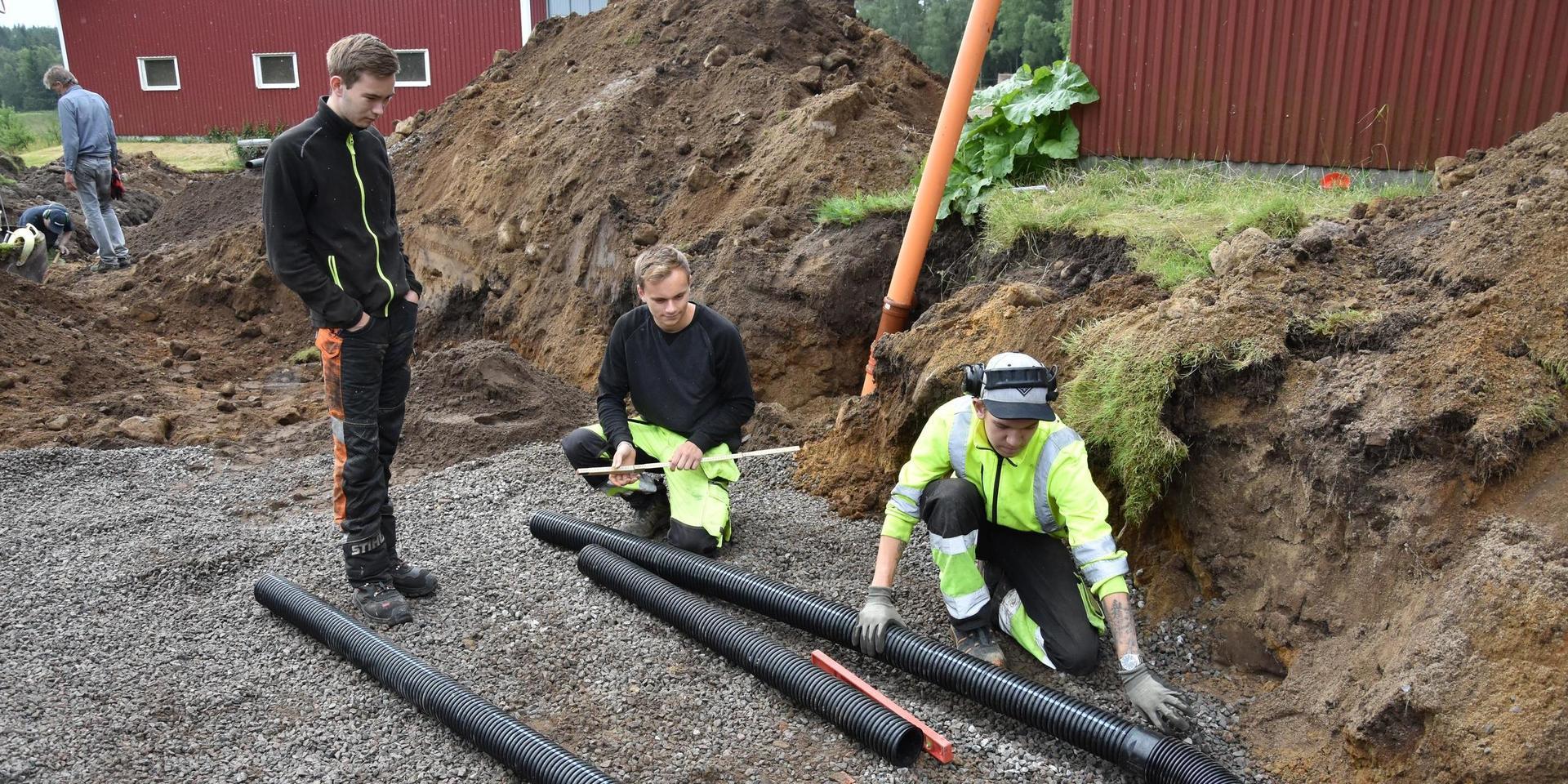 Filip Larsson, Adam Karlsson och Tim Remse mäter ut avståndet mellan avloppsrören.