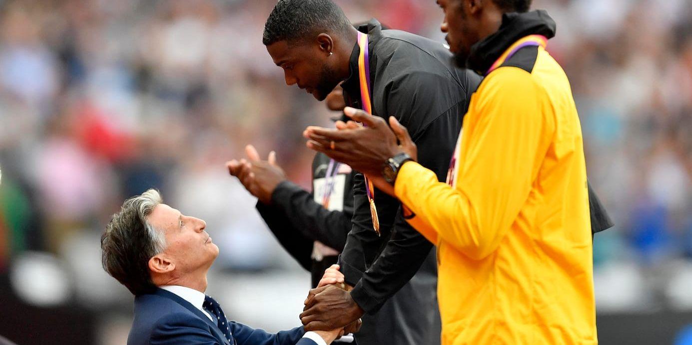 IAAF-basen Sebastian Coe (tv) delar ut guldmedaljen till Justin Gatlin (mitten) efter 100-metersfinalen i London 2017. Till höger applåderar Usain Bolt efter sitt sista individuella VM-lopp i karriären. Arkivbild.
