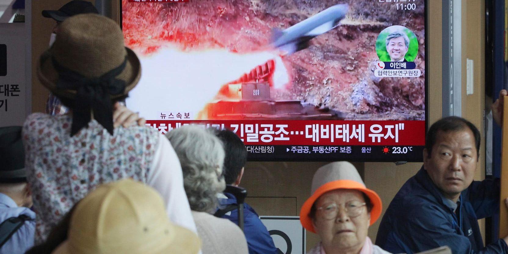 Människor i Seoul i Sydkorea tittar på tv-bilder på Nordkoreas robotuppskjutning.