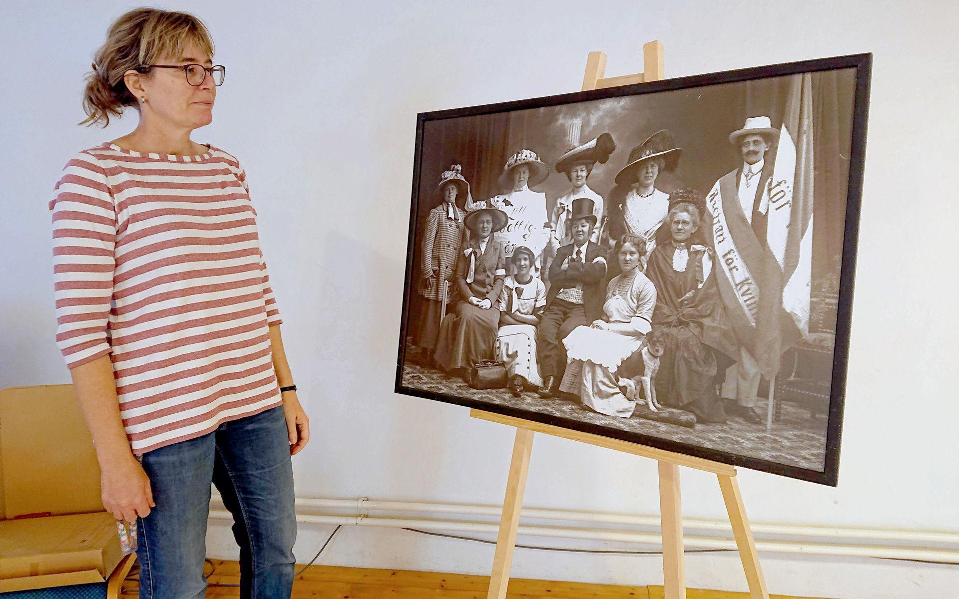 Anna-Lena Nilsson, länsarkivarie, och en bild på skådespelare ur Varbergs förening för kvinnans politiska rösträtt som satte upp en teater.