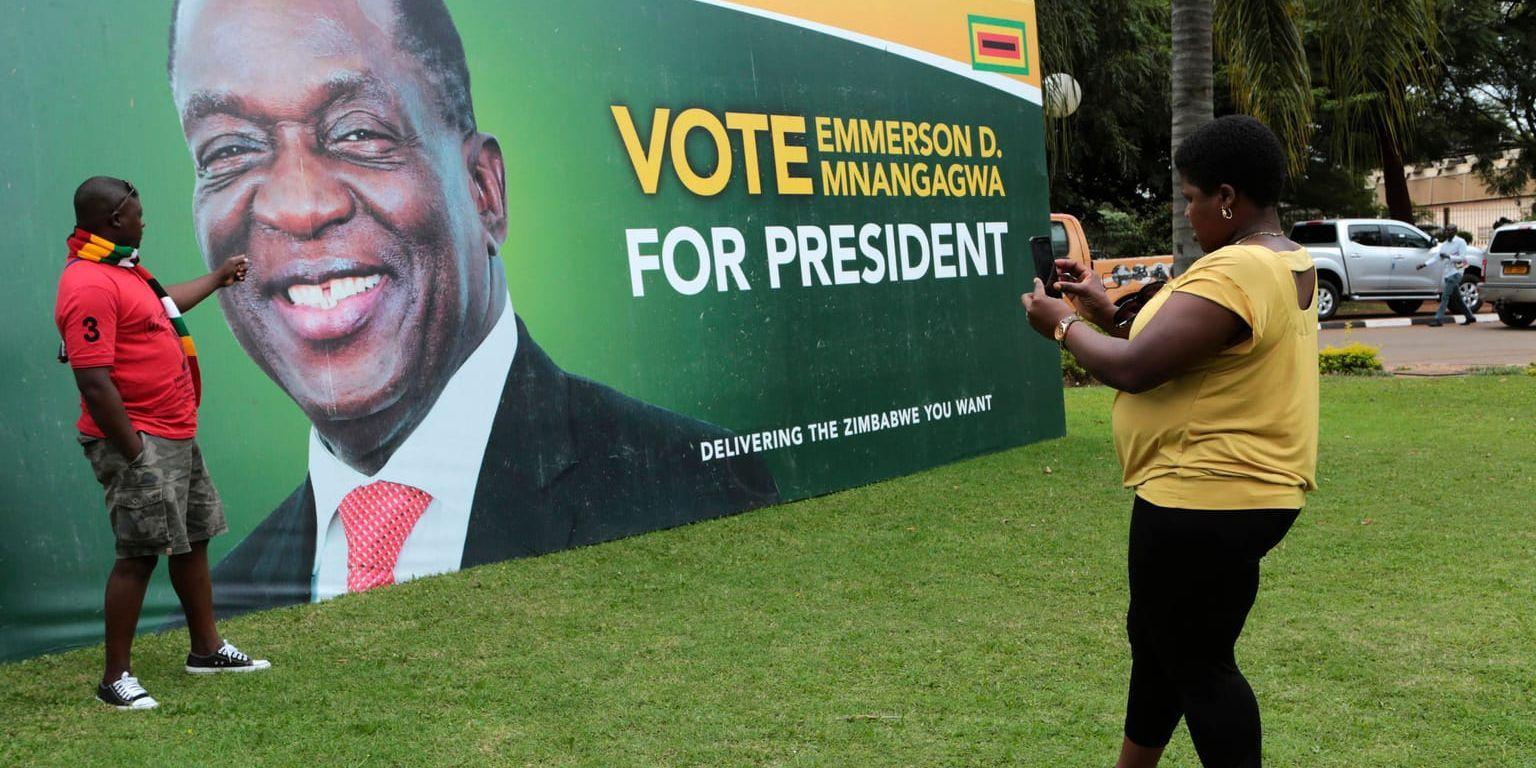 En man fotograferas framför valreklam för Zimbabwes president Emmerson Mnangagwa, i samband med att regeringspartiet Zanu-PF i början av maj lanserade sitt manifest inför det val som nu utlysts till den 30 juli.