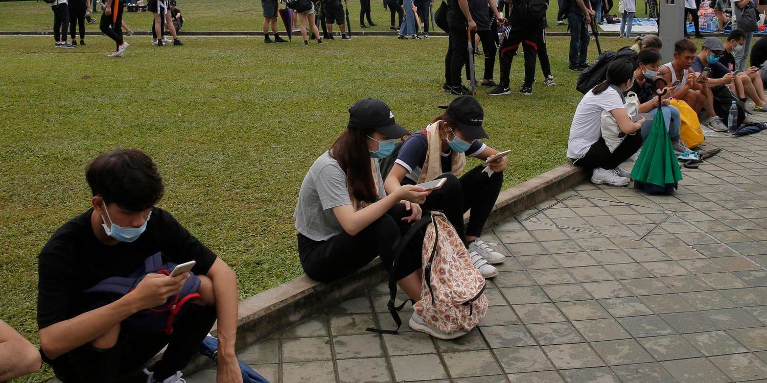 Demonstranter i Hongkong använder sina telefoner.