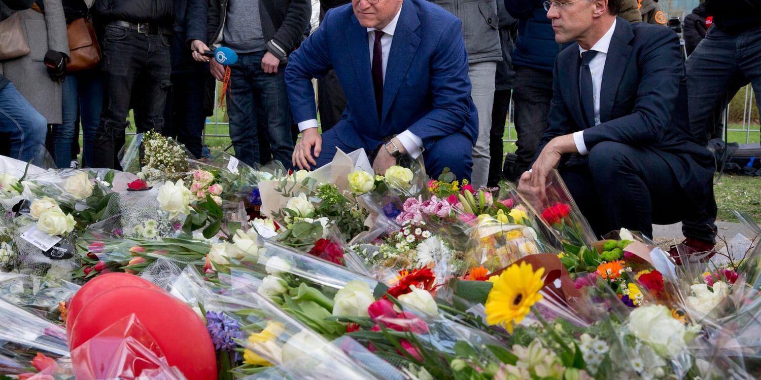 Nederländernas premiärminister Mark Rutte (till höger) och justitieminister Ferd Grapperhaus lägger blommor på 24 oktobertorget i Utrecht. I måndags sköts tre människor ihjäl på en spårvagn i staden.