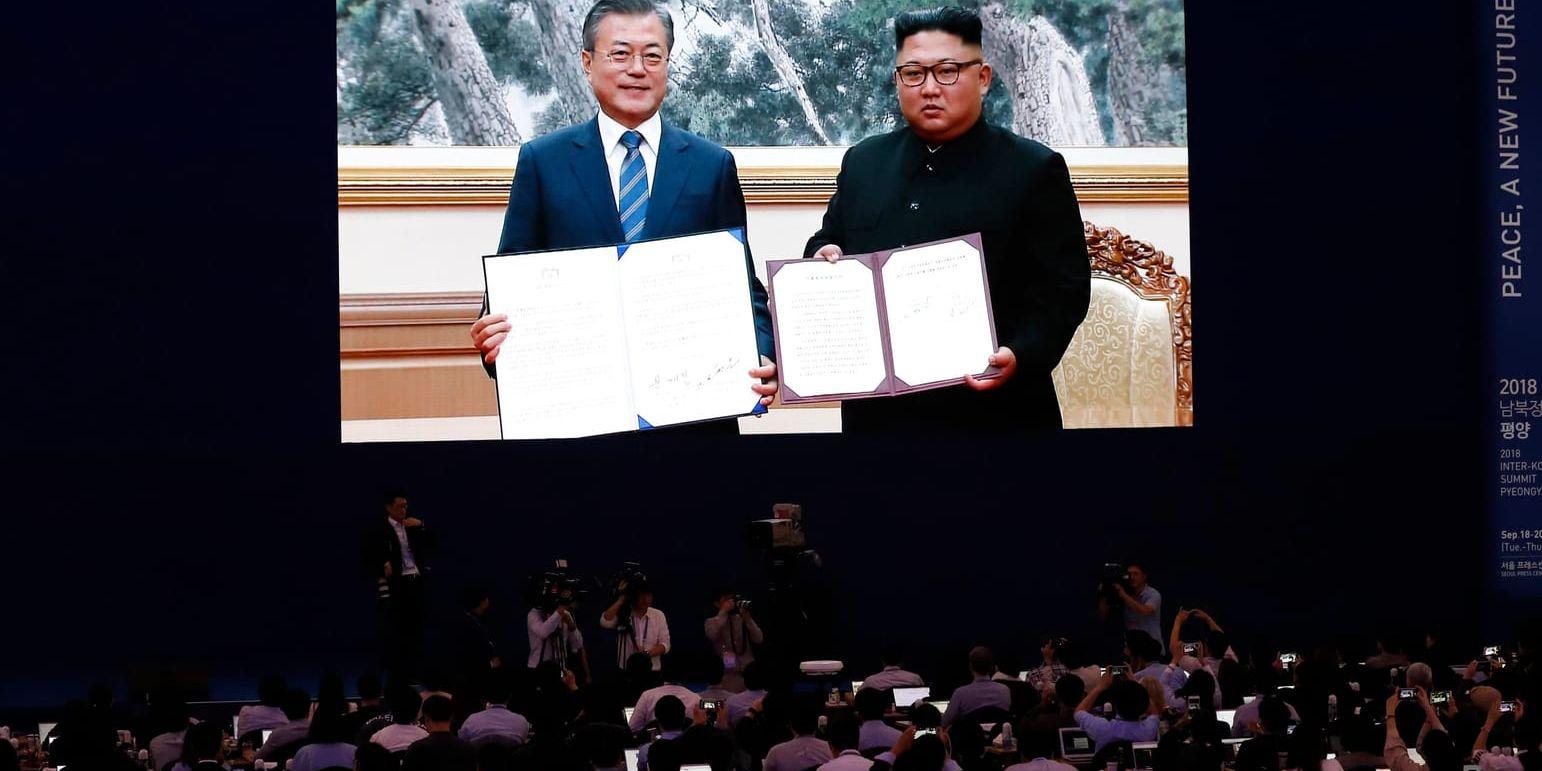 Journalister tittar på en stor skärm när Sydkoreas president Moon Jae-In och Nordkoreas diktator Kim Jong-Un visar upp undertecknade dokument efter onsdagens överläggningar.