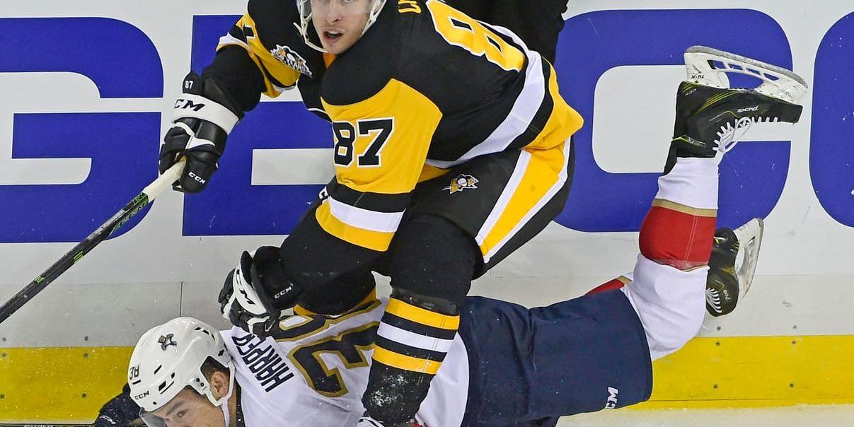 Shane Harper, i vitt, blir överkörd av Pittsburghs Sidney Crosby under dennes tid i NHL. Arkivbild.