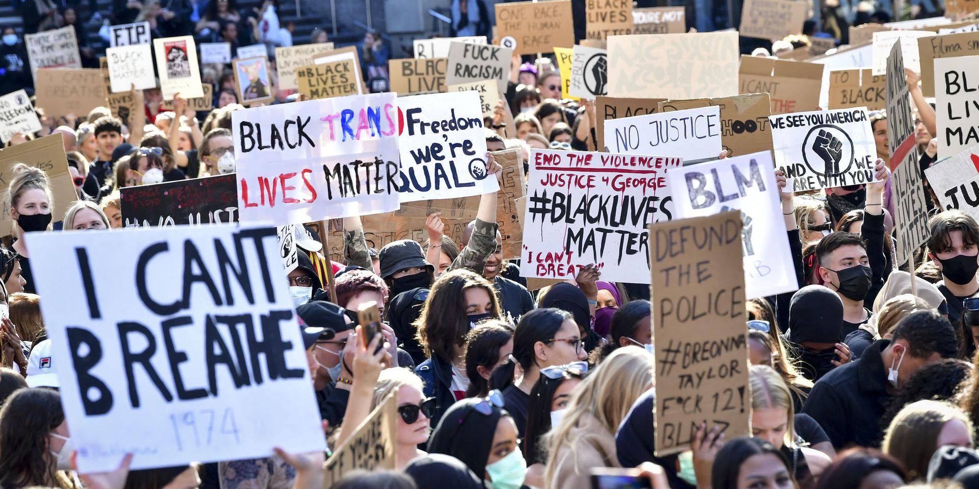 Deltagare med skyltar vid en tyst protest på Plattan, Sergels torg, i Stockholm City för att visa stöd för Black lives matter.