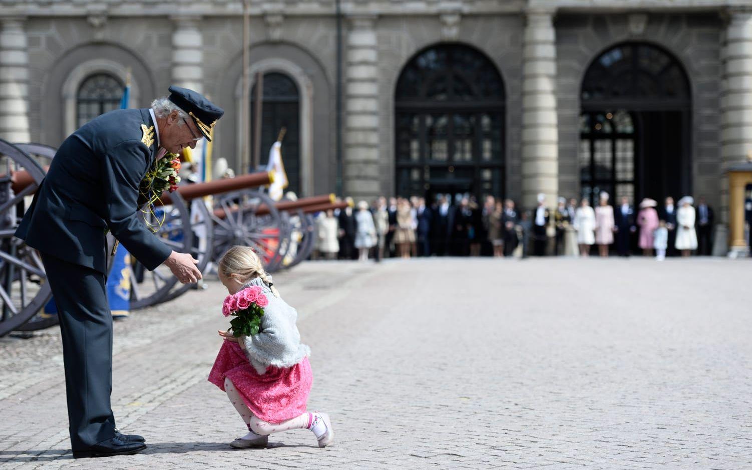 Kung Carl Gustaf tar emot blommor av en liten flicka på yttre borggården på Stockholms slott lördagen den 30 april med anledning av firandet av kung Carl Gustafs 70-årsdag. Foto: Henrik Montgomery