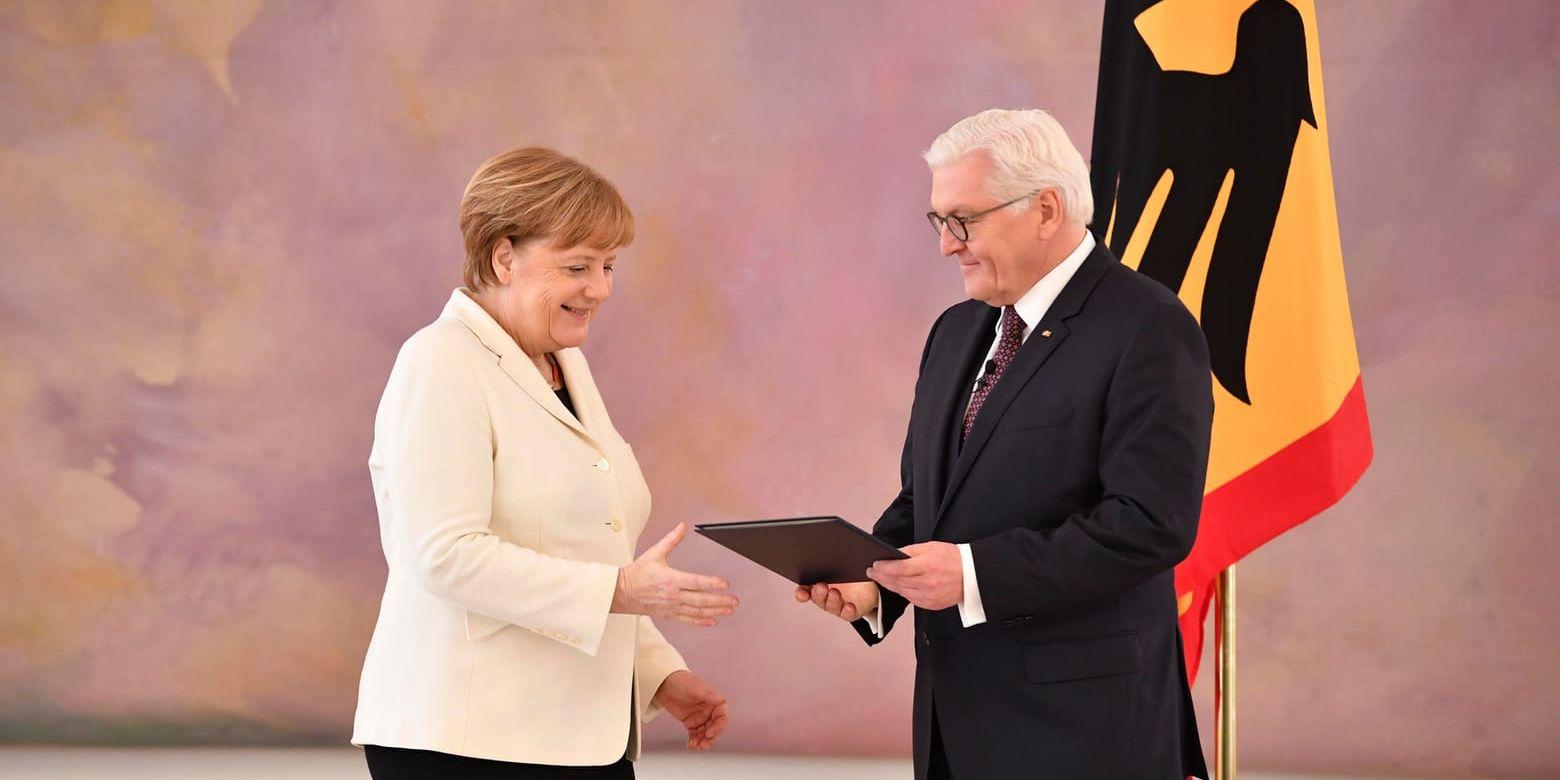 Tysklands president Frank-Walter Steinmeier lämnar över utnämningsbrevet till förbundskansler Angela Merkel vid en ceremoni i slottet Bellevue i Berlin.