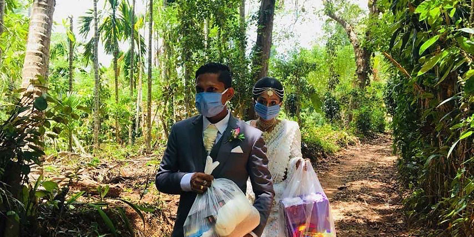 Darshana Kumara Wijenarayana och Pawani Rasanga ändrade sina bröllopsplaner när de gifte sig i slutet av april. De valde att fira i sin hemby Malimbada i Sri Lanka där de delade ut mat till behövande. Och enligt de nya riktlinjerna skulle de inte få stå så nära varandra som de gör på bilden. Arkivbild.