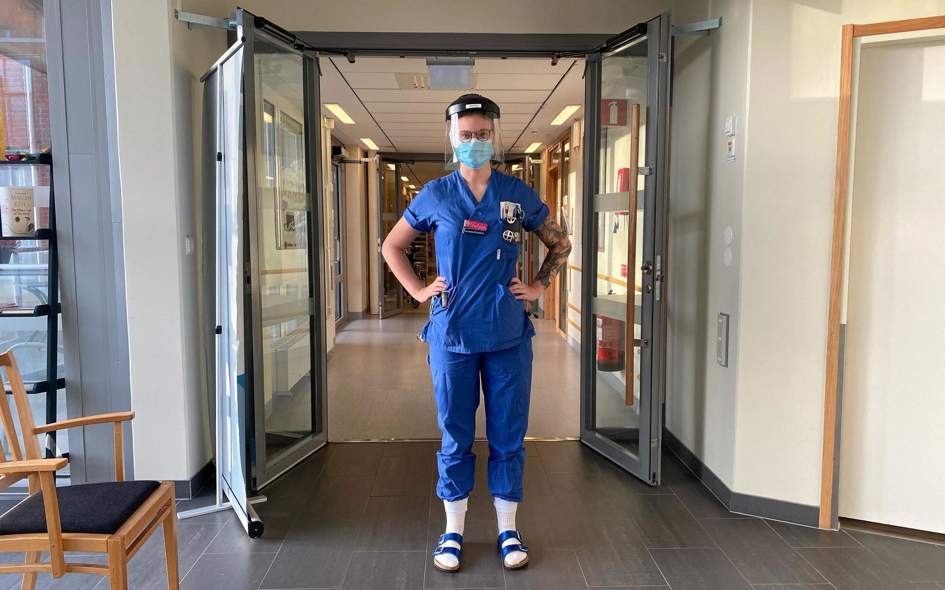 Natalie Karlsson utanför vårdavdelning med visir och munskydd. 