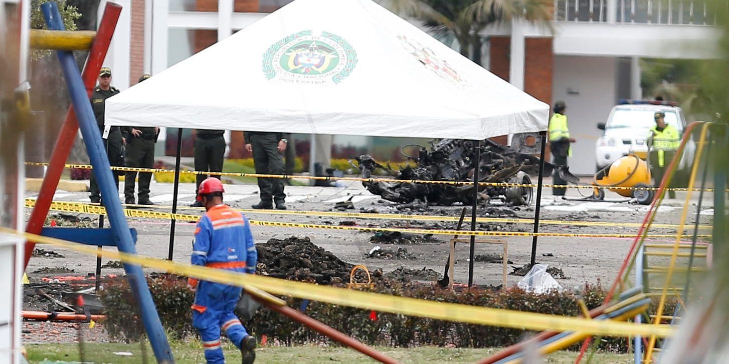 Poliser undersöker platsen där gärningsmannen detonerade en sprängladdning under en promoveringsceremoni för nya poliskadetter i Bogotá i torsdags.