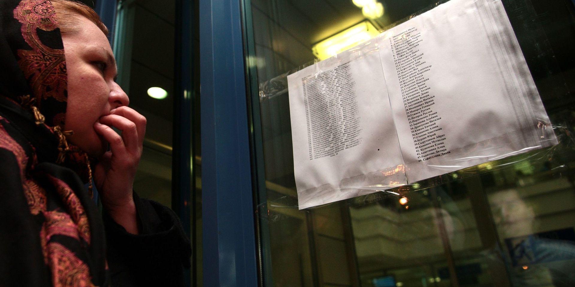 En kvinna läser namnen på passagerarlistan för flygplanet som kraschade i Kazan i Ryssland i november 2013. Arkivbild.
