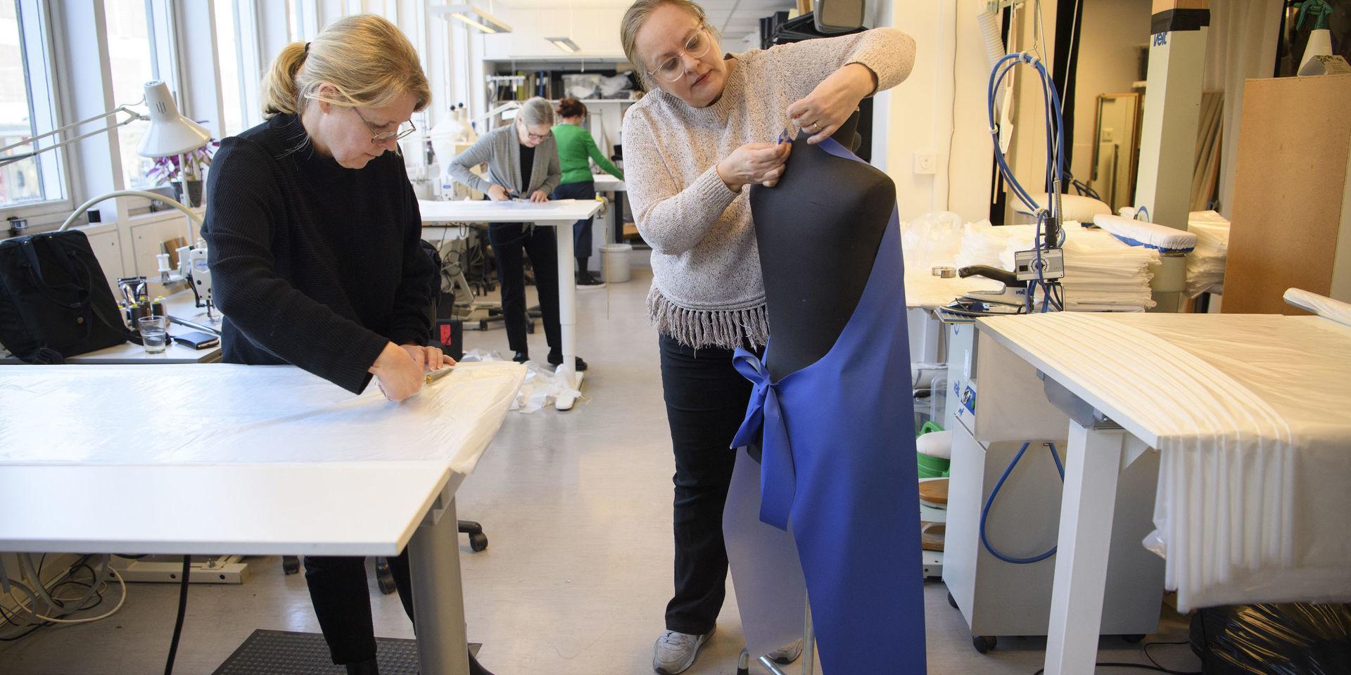 Anette Hovmark och Nancy Andreassen Peters provar ut ett skyddsförkläde. 