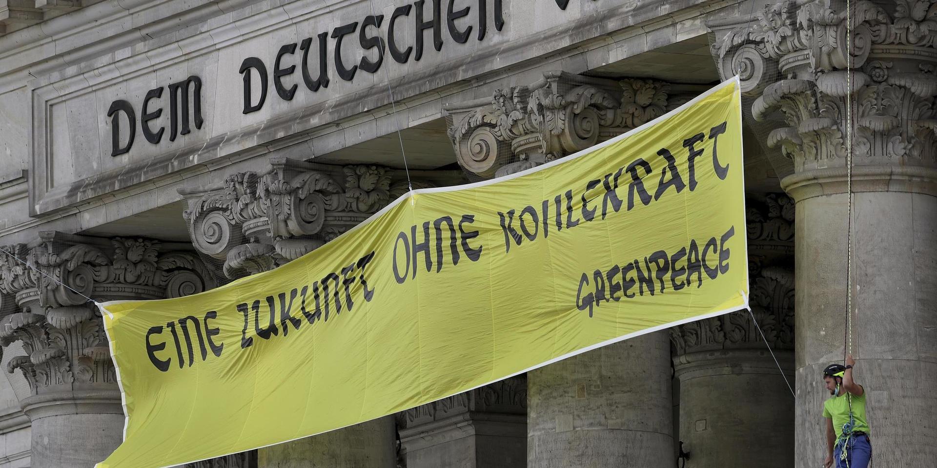 Miljöaktivister från Greenpeace förlängde på fredagen det tyska mottot 'Dem deutschen Volke' i Berlin med sin slogan 'Eine Zukunft ohne Kohlekraft' – vilket sammantaget kan översättas, 'En framtid utan kolenergi för det tyska folket'.