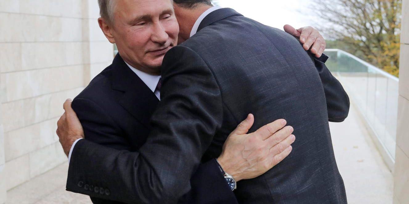 Vladimir Putin ger Syriens president Bashar al-Assad en kram i samband med deras möte i ryska Sotji i måndags.