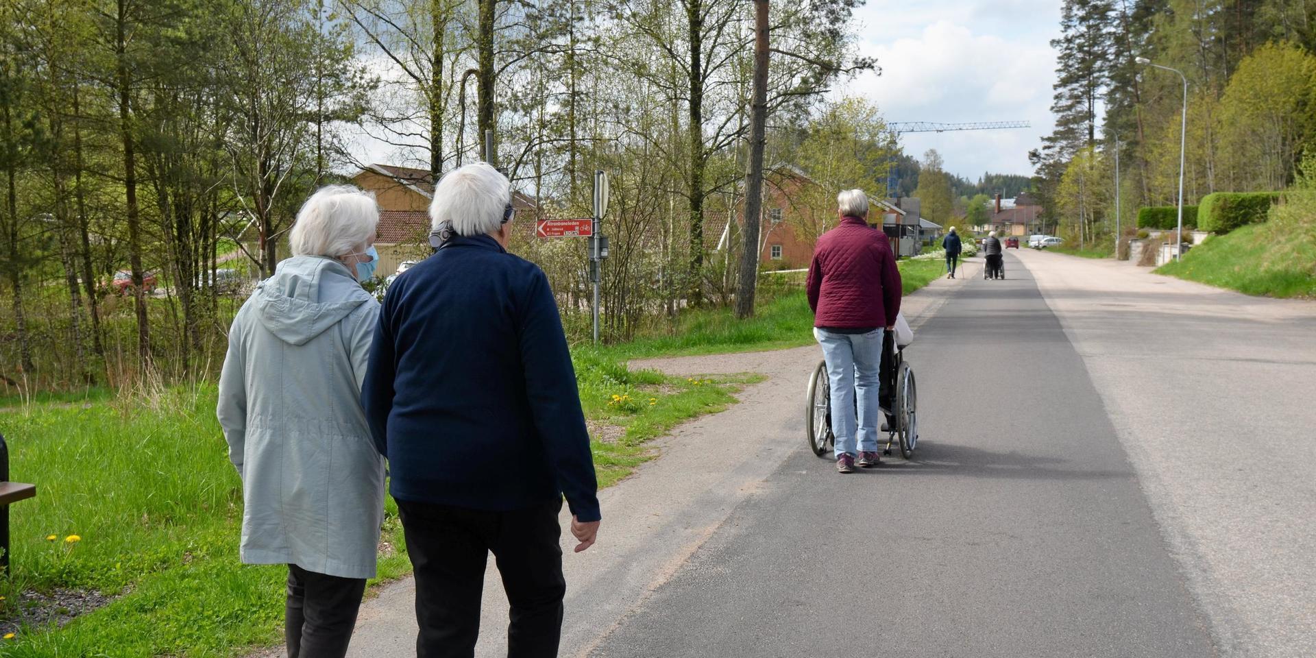 Frivilliga pensionärer på promenad med några av de boende på äldreboendet Furugården i Ullared.