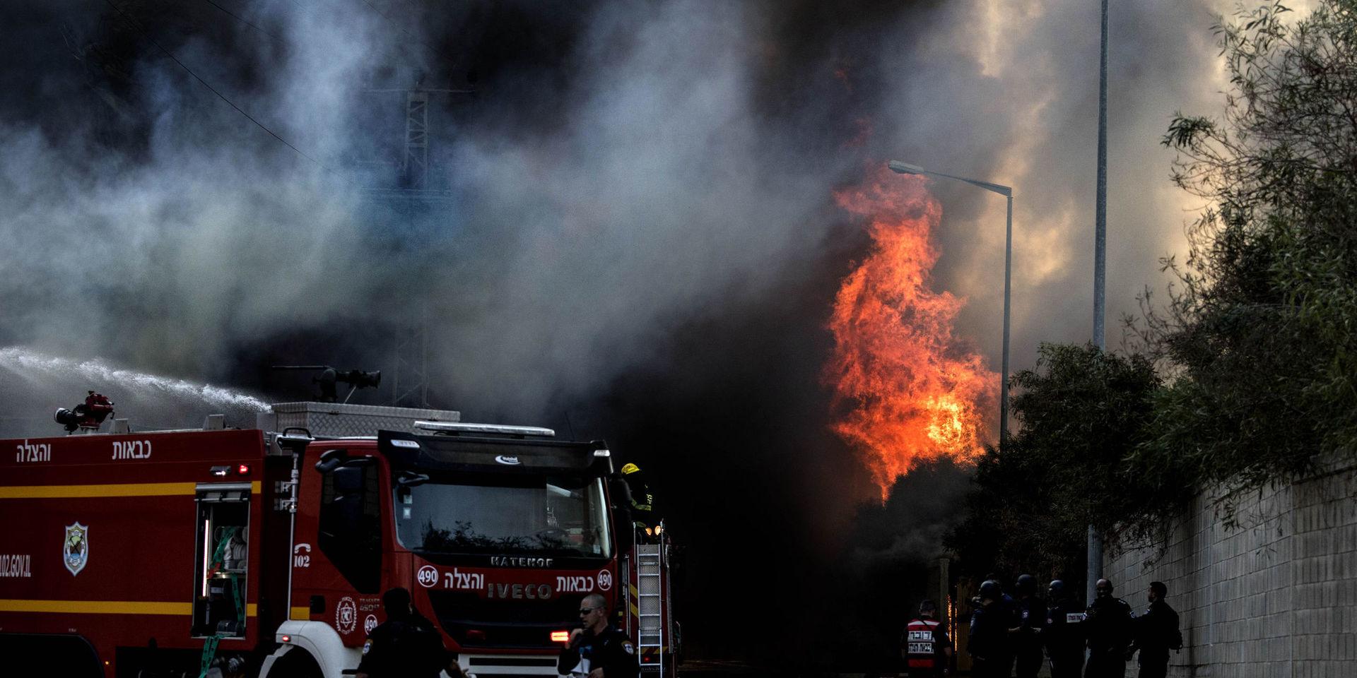 Brandkår bekämpar en brand som bröt ut i en fabrik i israeliska Sderot, efter att en raket träffat byggnaden.