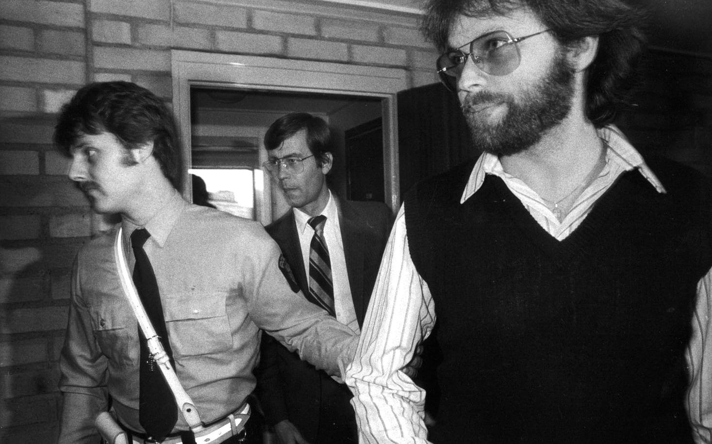 En bild från 1981 där Clark Olofsson förs till rättegång i Huddinge Tingsrätt. Clark Olofsson dömdes första gången 1966.