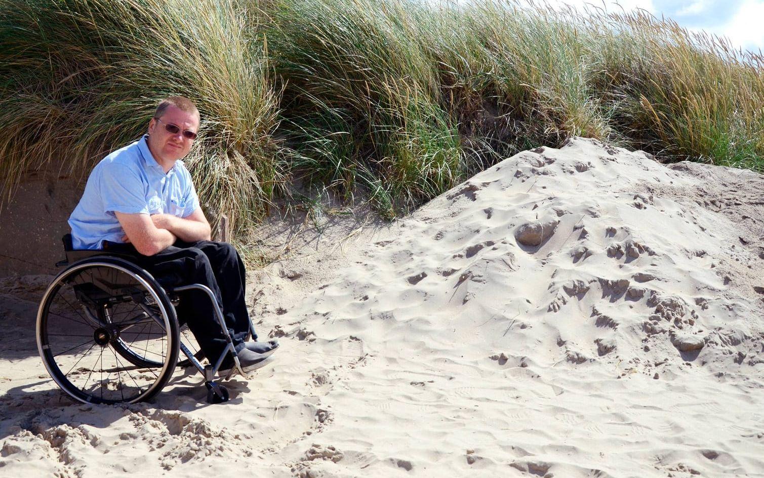 Här tar det stopp. Jonas Andersson har tidigare år kunnat komma ner till stranden. Nu plogar kommunen upp sanden på sidorna av gången så rullstolar, barnvagnar och rullatorer har problem att komma ner.