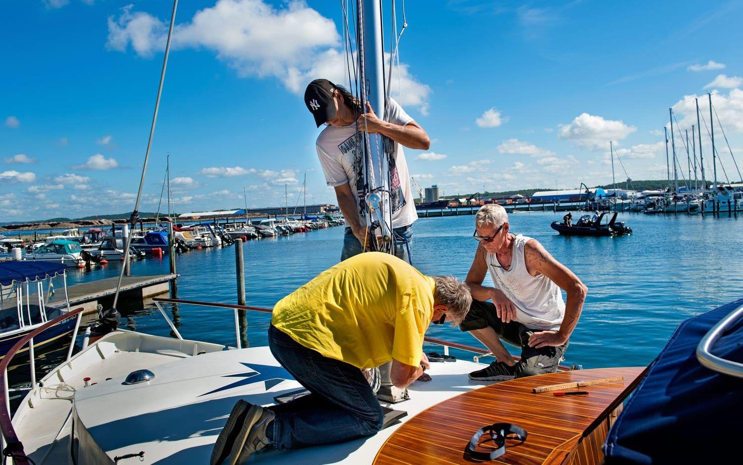 Mastigt. I nio år har Göran Söderberg från Borås, till vänster, renoverat sin båt. Nu får han hjälp av Thomas Grankvist, stående, och Erik Routsi, i gult, att masta på sitt renoveringsprojekt för första gången. Foto: Aline Lessner