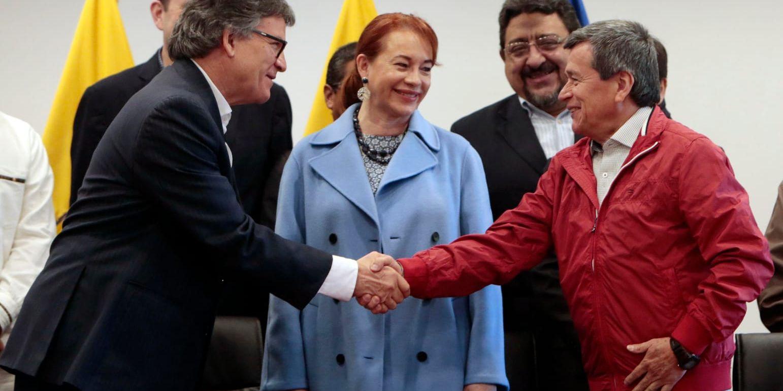 Den colombianska regeringens representant Gustavo Bell, till vänster, skakar hand med ELN-representanten Pablo Beltrán under ett möte i Quito i slutet av mars.