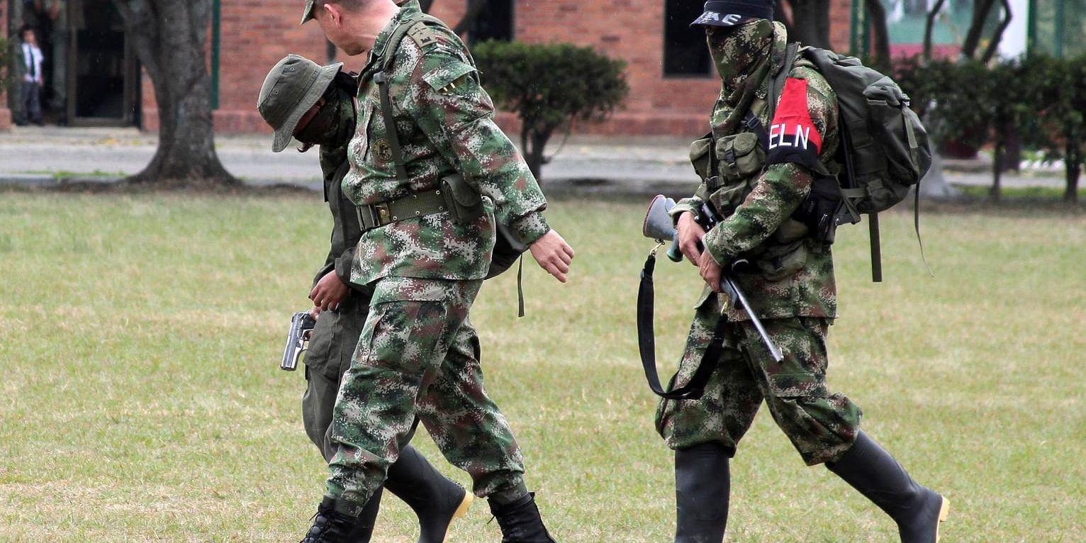 En colombiansk soldat eskorterar två medlemmar ur ELN-gerillan som kapitulerat. Arkivbild.