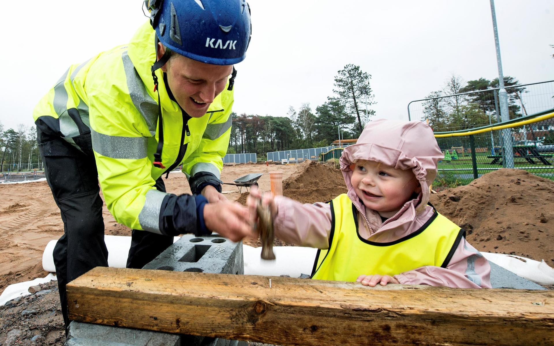 2-åriga Bailey Jakobsson får hjälp av platschef Petter Frisk på RA-Bygg med att slå i första spiken till  Eldstadens förskola.