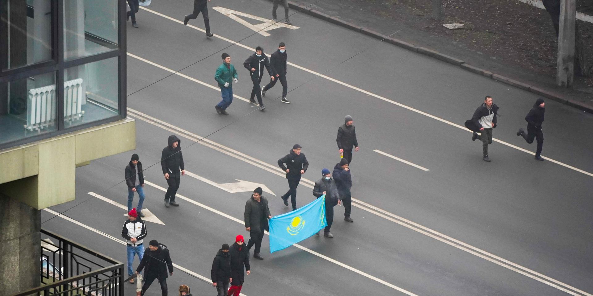 Demonstrators with Kazakhstan&apos;s national flag march during a protest in Almaty, Kazakhstan, Wednesday, Jan. 5, 2022. Demonstrators denouncing the doubling of prices for liquefied gas have clashed with police in Kazakhstan&apos;s largest city and held protests in about a dozen other cities in the country. (AP Photo/Vladimir Tretyakov)  XAZ126