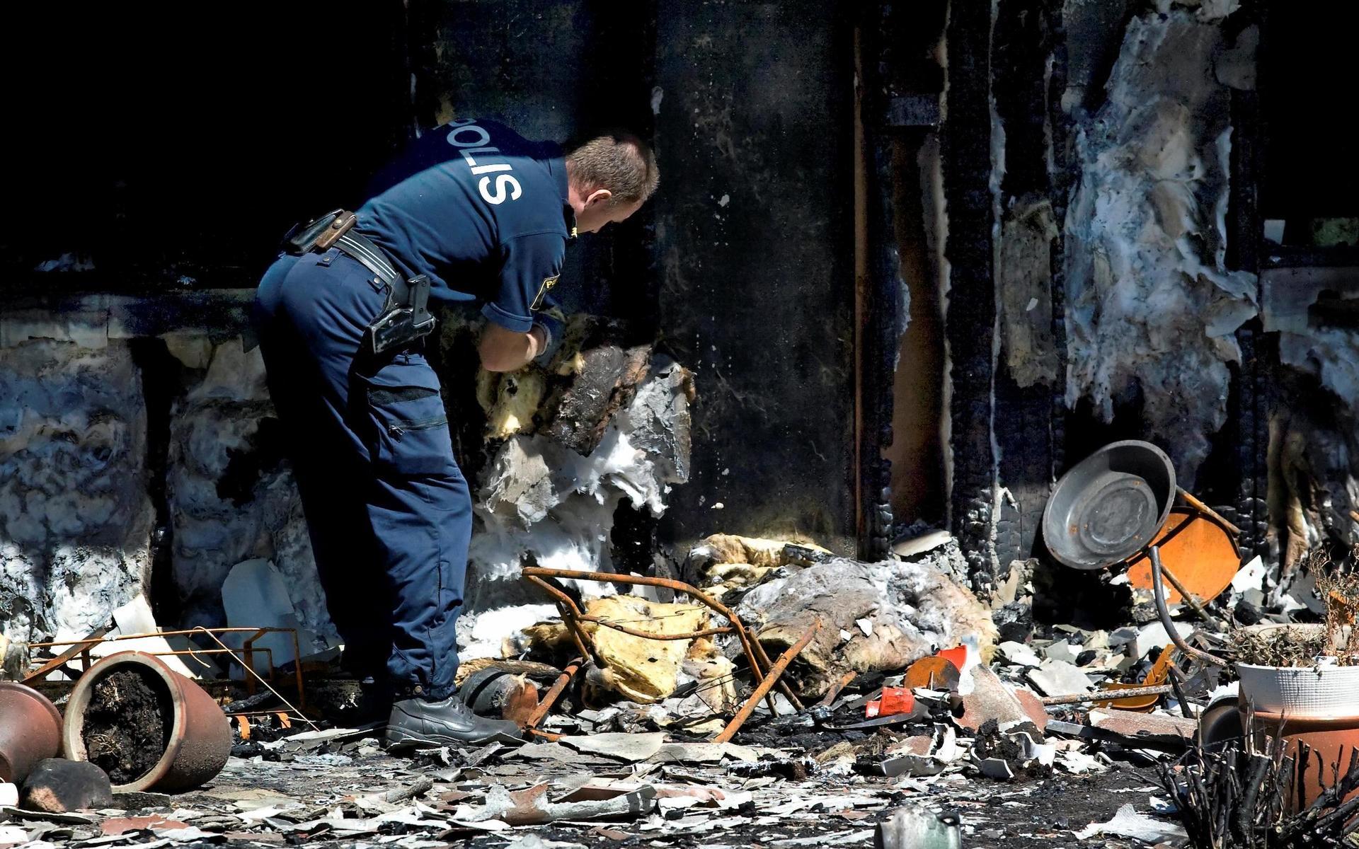 Polisens tekniker går igenom brandresterna ett par dagar efter branden sommaren 2008. Utredningen kommer fram till att branden startade med ett stearinljus som föll ner i en dyna på en uteplats.