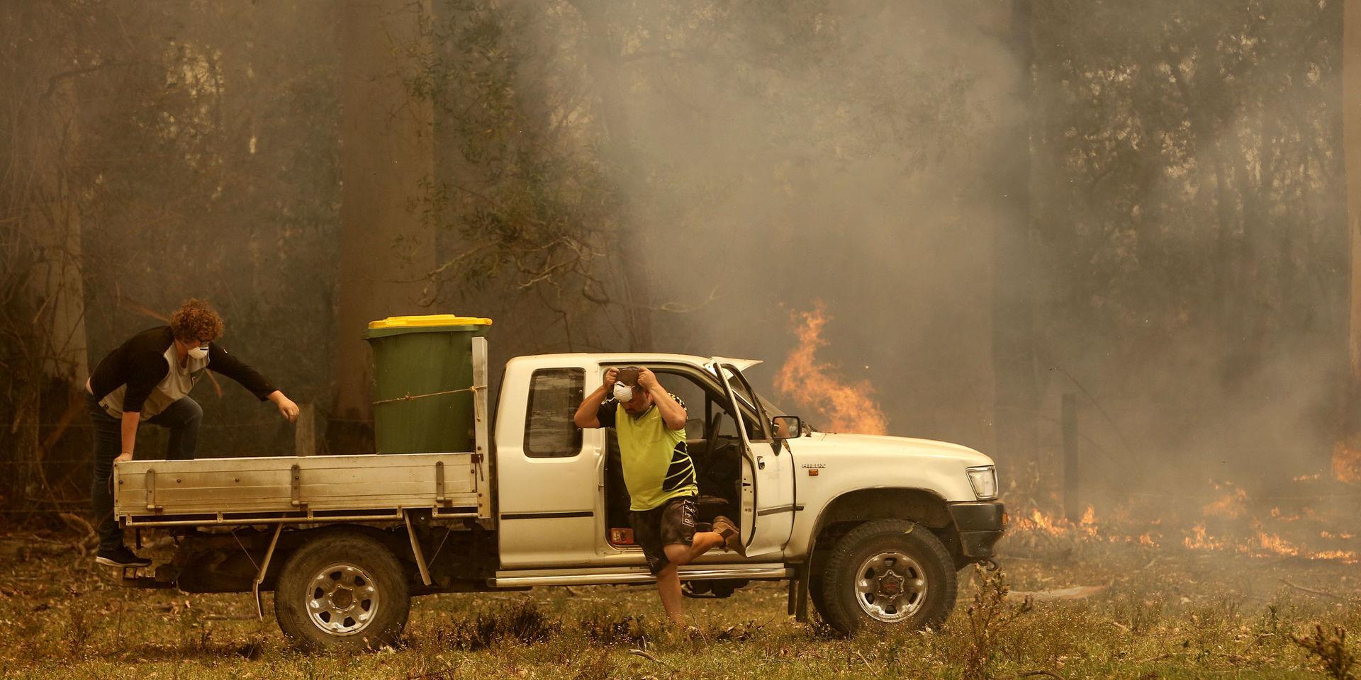 Två personer förbereder sig för att stoppa en brand i Koorainghat nära Taree i New South Wales på tisdagen.