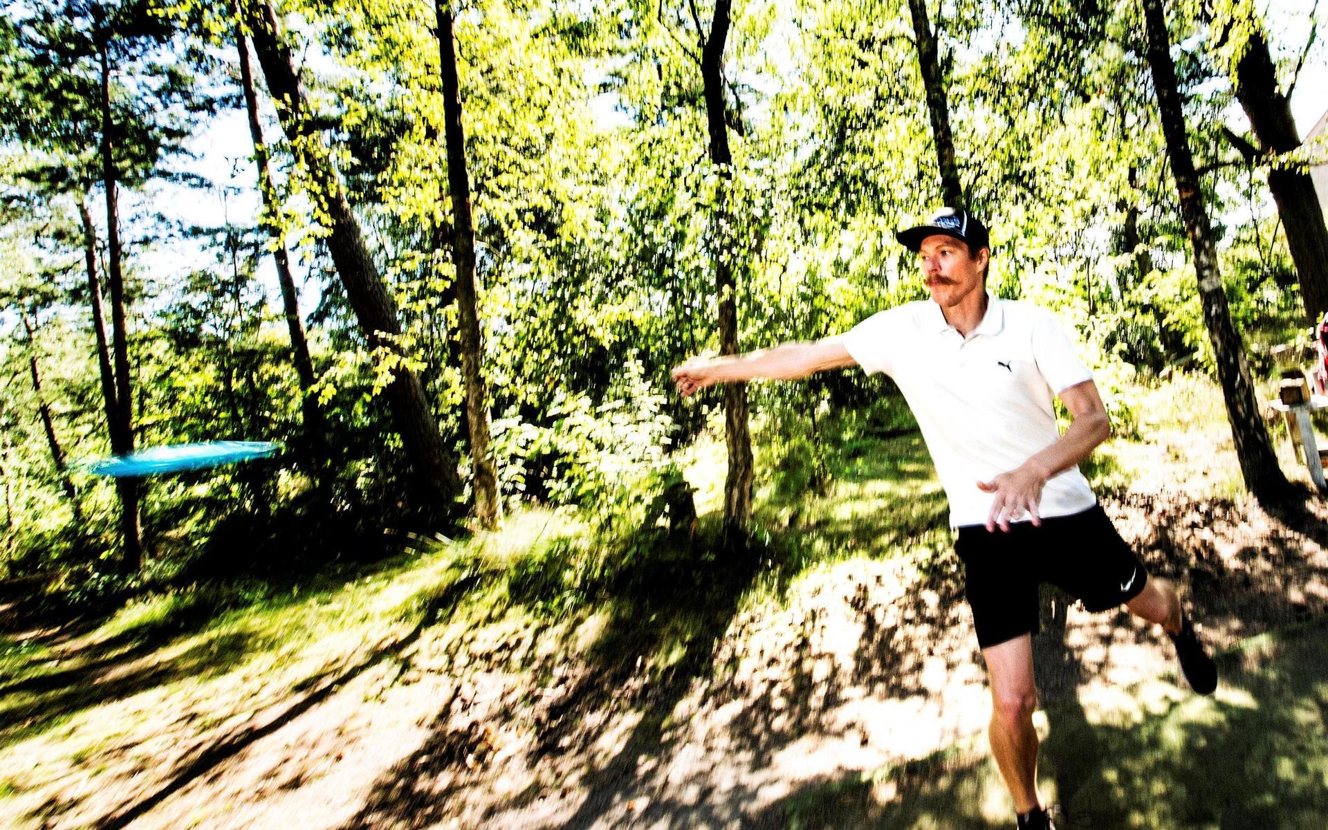 Jens Karlsson tar sats och kastar sin disk från tee på bana nummer 1 på Vallarnas discgolfbana.